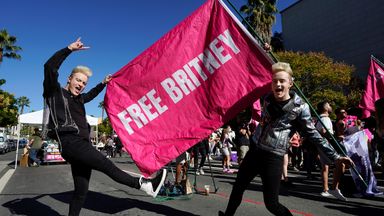 Edward, right, and John Grimes - aka Jedward - hold a 'Free Britney' flag outside a hearing on the pop singer's conservatorship at the Stanley Mosk Courthouse. Pic: AP/Chris Pizzello      